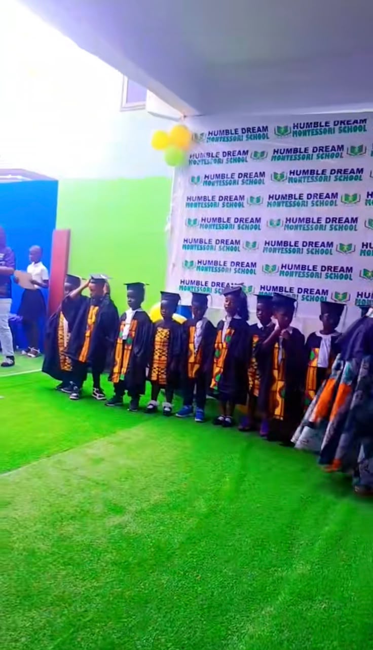 Graduating pupils in caps and gowns lined up at Humble Dream Montessori School