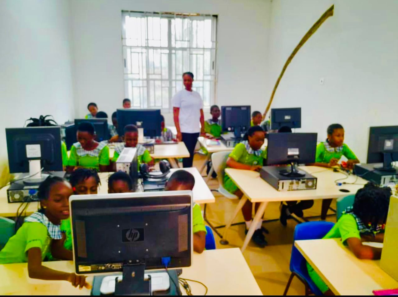 Pupils working at computers in the school ICT lab with their teacher