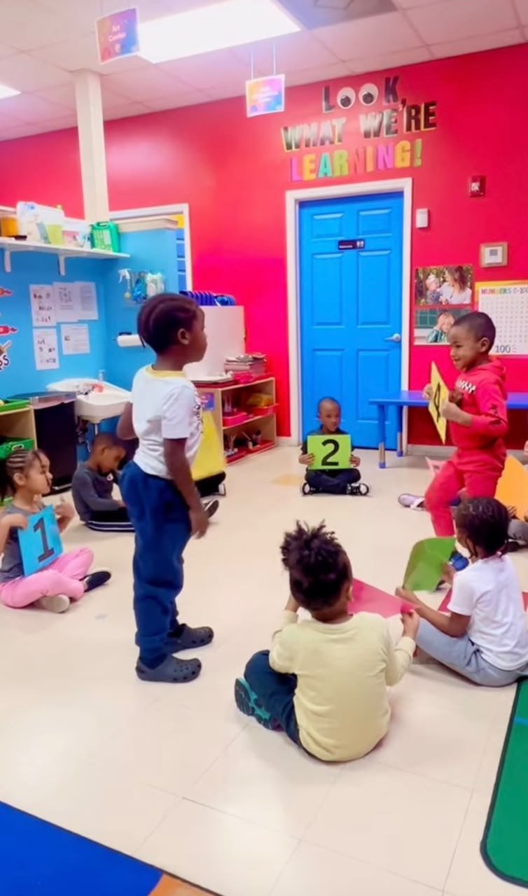 Young pupils holding number cards during a hands-on counting activity