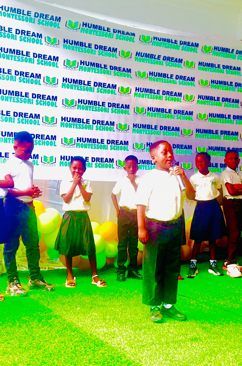 Pupils speaking into a microphone during a school event at Humble Dream Montessori School