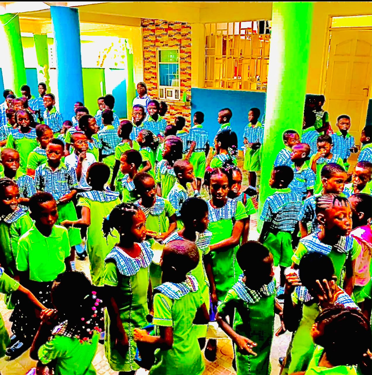 Pupils in green and blue uniforms gathered in the school courtyard